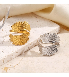 Detaillierte Nahaufnahme von Engel-Flügel Ringen in Gold und Silber auf Steinplatte