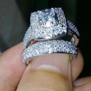 Detalle del conjunto de anillos de plata con circón cuadrado corte princesa en la mano