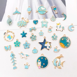 Assortimento di ciondoli in smalto blu e oro con unicorno sirena e motivi oceanici