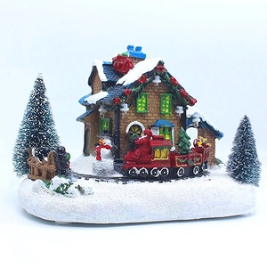 Détail d'une maison de Noël LED avec Père Noël sur train rouge et bonhommes de neige