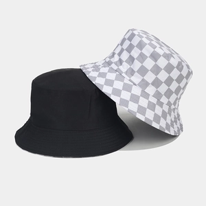 Detail view of cotton bucket hats in solid black and grey checkerboard pattern