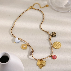 Close-up of 18K gold plated charms on multi-color woven cord with pearls and leopard pendant