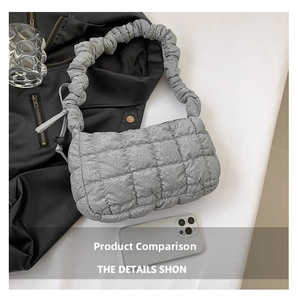 Close-up of silver quilted puffy shoulder bag with ruched handle and glitter texture
