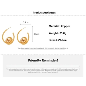 Macro view of C-shaped gold hoop earrings with spiral texture and measurements