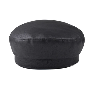 Detailed view of black PU leather baker boy cap with textured stitching on white background
