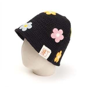 Detail of handmade black crochet bucket hat with colorful floral knit patches and HF label