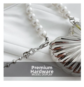 Close-up of metallic heart bag with elegant pearl strap and polished silver finish