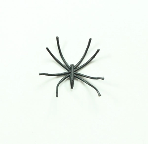 Top view of a small black plastic spider toy for Halloween decorations on white background
