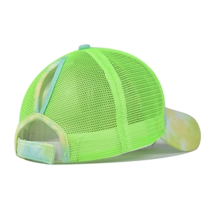 Detail of neon green ponytail visor cap featuring tie-dye brim and breathable mesh back