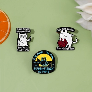 Detail of cartoon cat enamel pins featuring humorous phrases on a light green surface