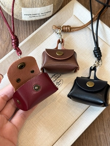Detail of mini leather earphone pouches in burgundy and brown with snap closure