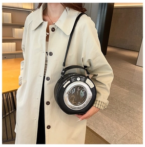 Close-up of creative black washing machine shaped crossbody bag with silver hardware