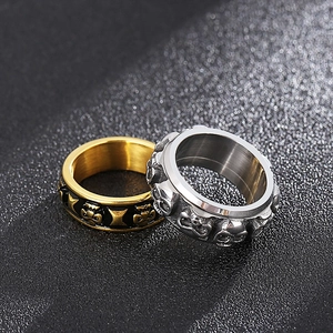 Detail of silver skull relief and gold cross patterns on punk style stainless steel rings