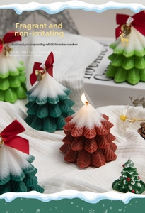 Detail of Christmas tree scented candles with leaf texture, ribbons and golden bells