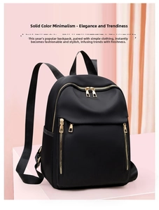 Detail of black nylon backpack featuring gold hardware zippers and three front pockets