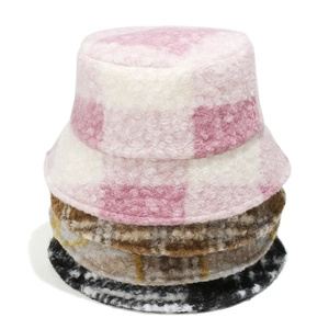 Detail view of plaid teddy fleece bucket hats in pink, brown, and black patterns