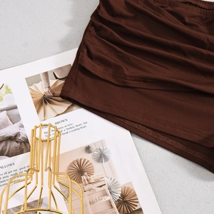Detailed macro view of brown ribbed knit hot pants with textured pleats and metal detail