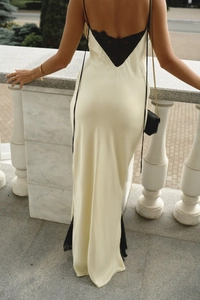 Detail of elegant backless satin dress with black lace trim and silk-like finish