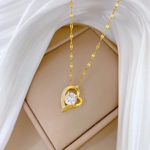 Elegant gold heart necklace with central round crystal and pavé stones on silk