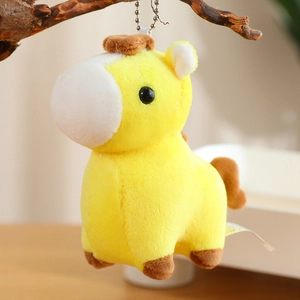 Detail of yellow plush pony keychain showing soft texture hanging on a branch