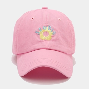 Pink cotton baseball cap with embroidered flower and STUDIO text on a grey background