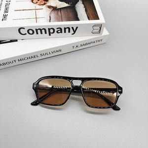 Detalle de gafas de sol vintage con adornos XX metálicos y lentes marrones sobre libros