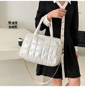 Detail of silver quilted puffer tote bag showing glossy texture and diamond stitching