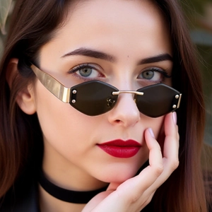 Close-up of diamond-cut rimless sunglasses with gold metal temples and black lenses