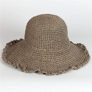 Close-up of the crochet straw sun hat featuring a wavy ruffle brim in earthy taupe