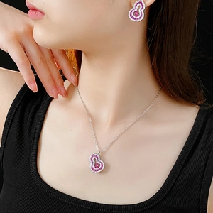 Macro detail of model wearing silver gourd jewelry set with pink stones and diamonds