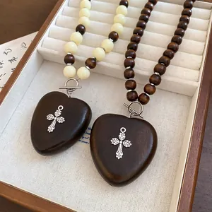Collier ethnique en perles de bois avec pendentif cœur croix et fermoir à bascule