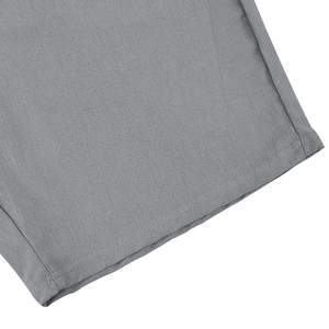 Detailed close-up of grey linen fabric showing high-quality double-stitched hem and texture