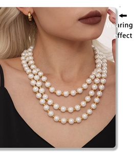 Close-up of triple-layered pearl necklace with golden beads on a model's neck