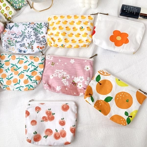 Detailed top view of assorted mini floral and fruit print canvas pouches with zippers