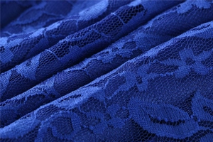 Detailed close-up of dark blue floral lace fabric showing intricate patterns and texture