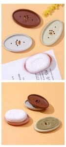 Close-up of silicone soap holder with paw-shaped drainage holes and cleaning bristles