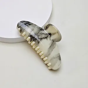 Detail of premium marble pattern hair claw clip with smooth beige acetic acid finish