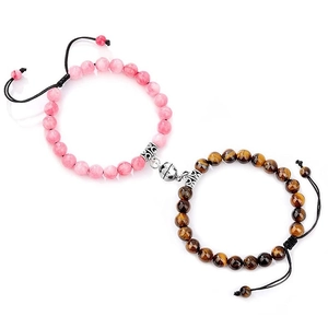 Detail of couple magnetic heart bracelets with pink beads and tiger eye natural stones