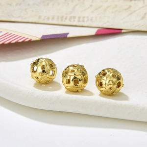 Macro shot of 8-9mm hollowed golden metal beads for DIY jewelry making and crafts