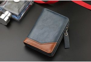 Detail of short blue and brown PU leather wallet with metallic zipper on black surface