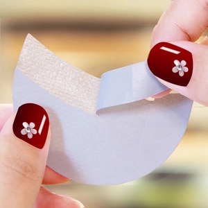 Self-adhesive moon-shaped eyeshadow shield being peeled for eyelash extensions