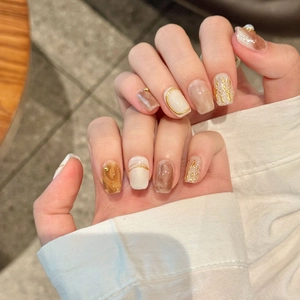 Baroque style press-on nails with marble texture, gold foil, and pearl accents