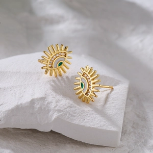 Gold plated evil eye stud earrings with green zircon and sunburst design on stone