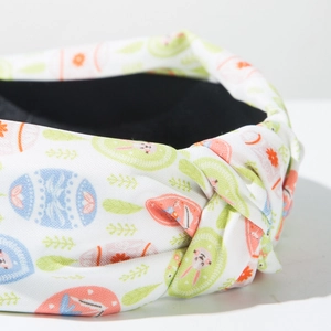Detail of Easter knotted headband with rabbit and egg print on white fabric texture