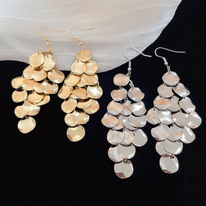 Close-up of layered metal sequins on gold and silver drop earrings with fishhook wires