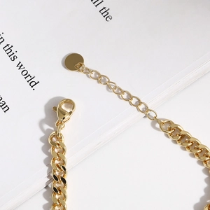 Gold paperclip bracelet with evil eye design and adjustable lobster clasp closure