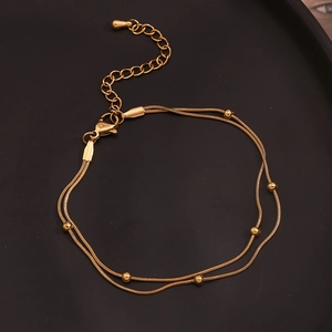 Detail of 18K gold-plated stainless steel double-layered anklet with small gold beads