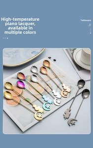Close-up of stainless steel dessert spoons with moon and star shapes on marble tray