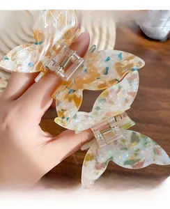 Close-up of butterfly hair claw clips with iridescent tortoiseshell patterns and gold spring