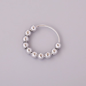 Minimalist silver fidget ring with rotating beads for anxiety relief on a clean background